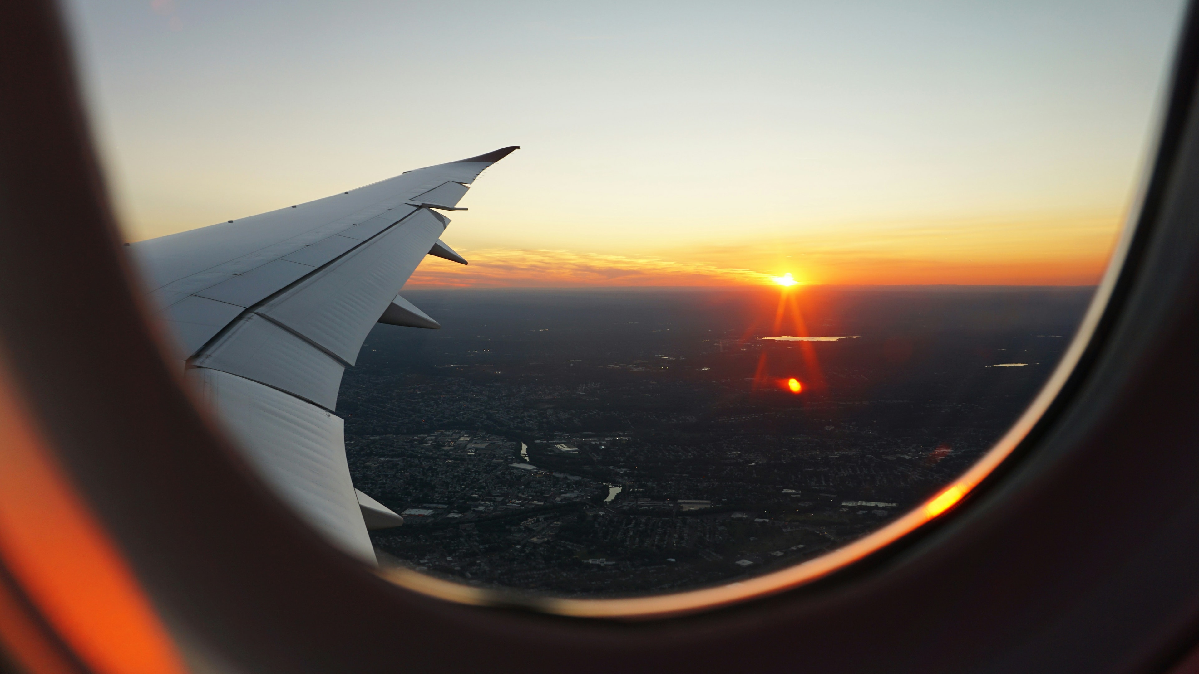 Airplane window view of a stunning sunset over the clouds during flight